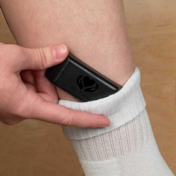 Person putting black Bi-Tapp tapper in sock